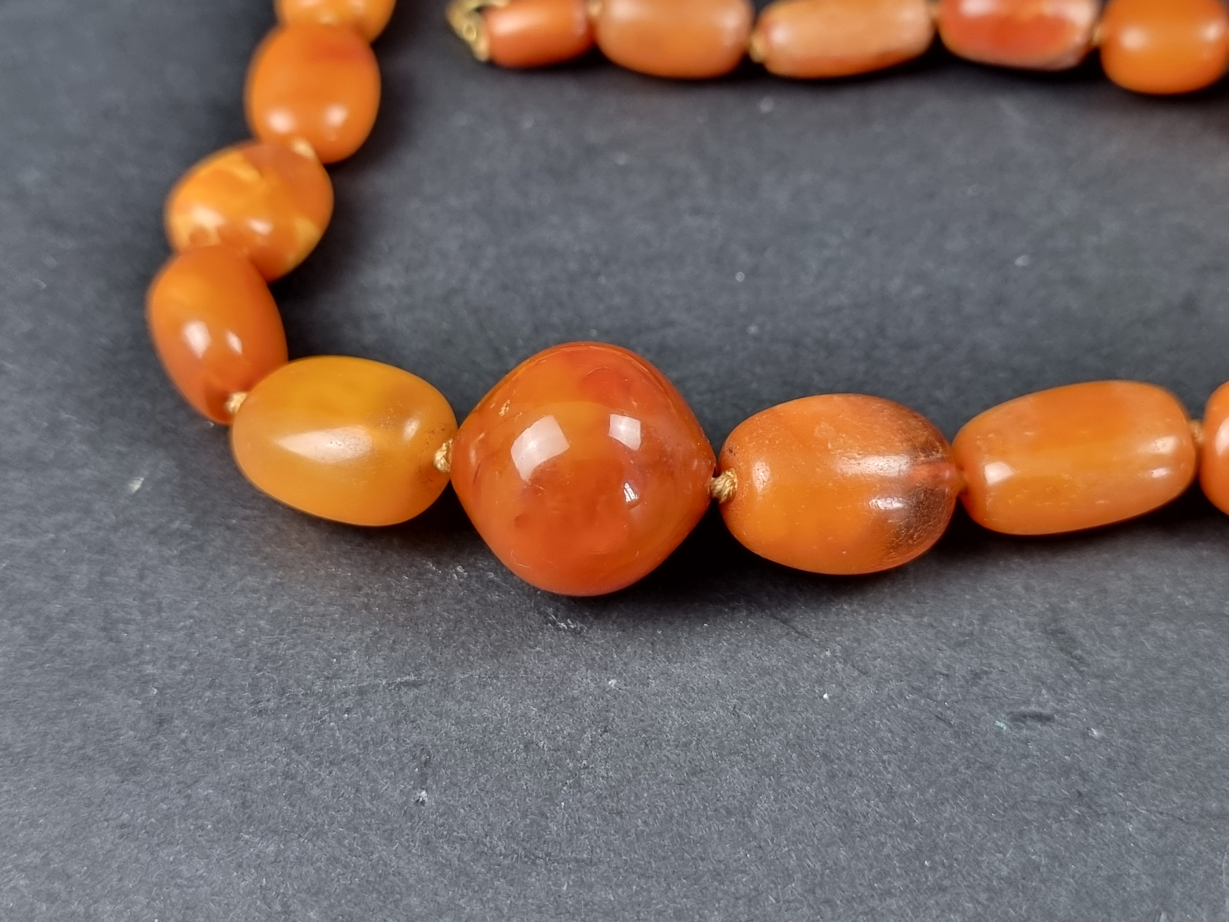 An amber bead necklace, having clasp stamped '375', 46cm long, gross weight 49.1g. - Image 2 of 6