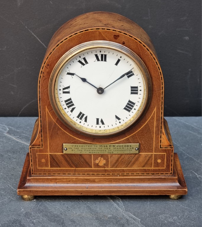 An early 20th century mahogany and inlaid mantel timepiece, 18cm high, (repairs to dial).