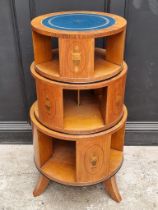 An unusual satinwood and inlaid three tier revolving bookcase, of 'wedding cake' form, each tier