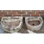 Two antique stone semi-circular troughs, largest 52cm wide.