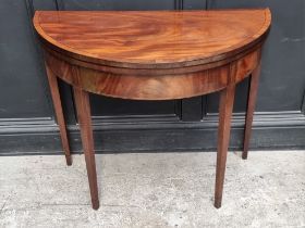 A George III mahogany and line inlaid demi-lune tea table, with double gateleg action, 95cm wide.