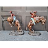 After Frederic Remmington, a pair of bronze cowboys, largest 51cm high. (2)