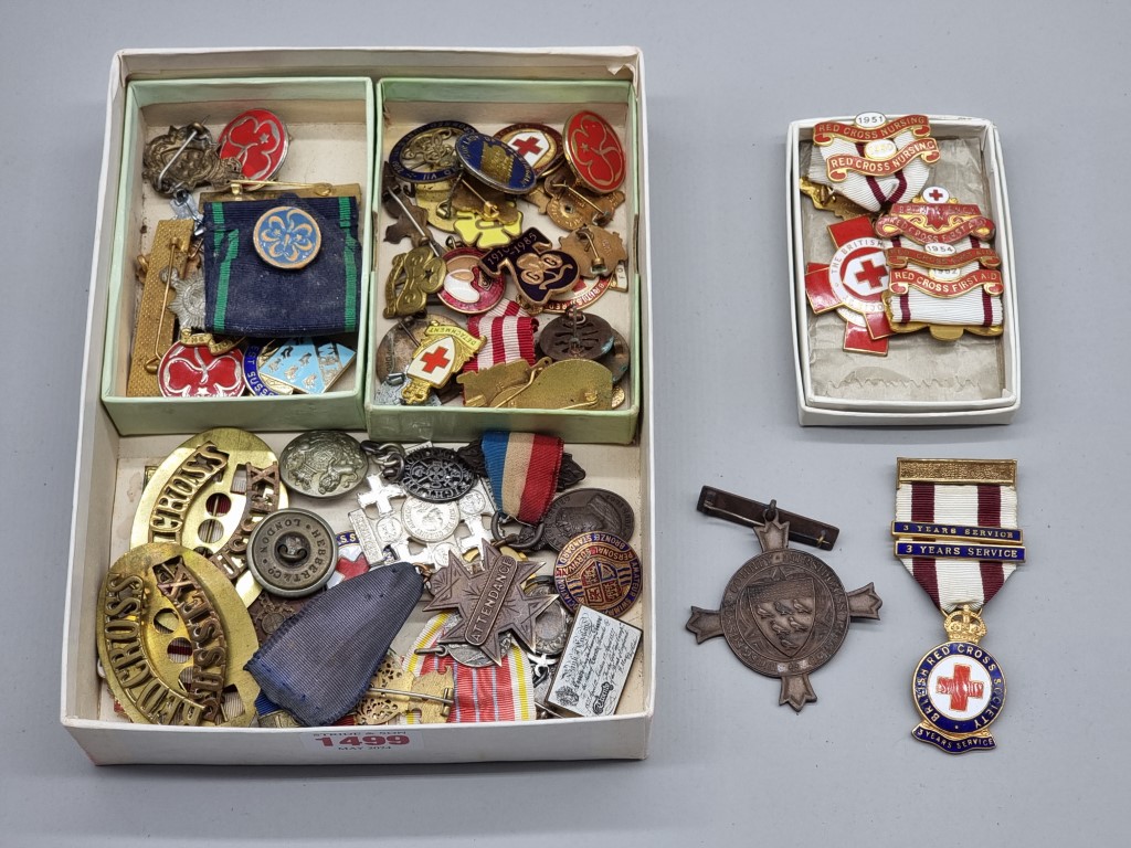 A collection of Red Cross and other similar medals and badges.