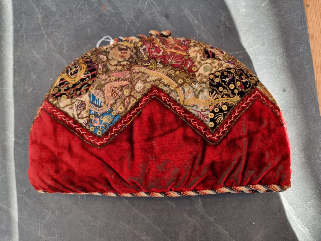A Victorian embroidered tea cosy, 34cm wide.