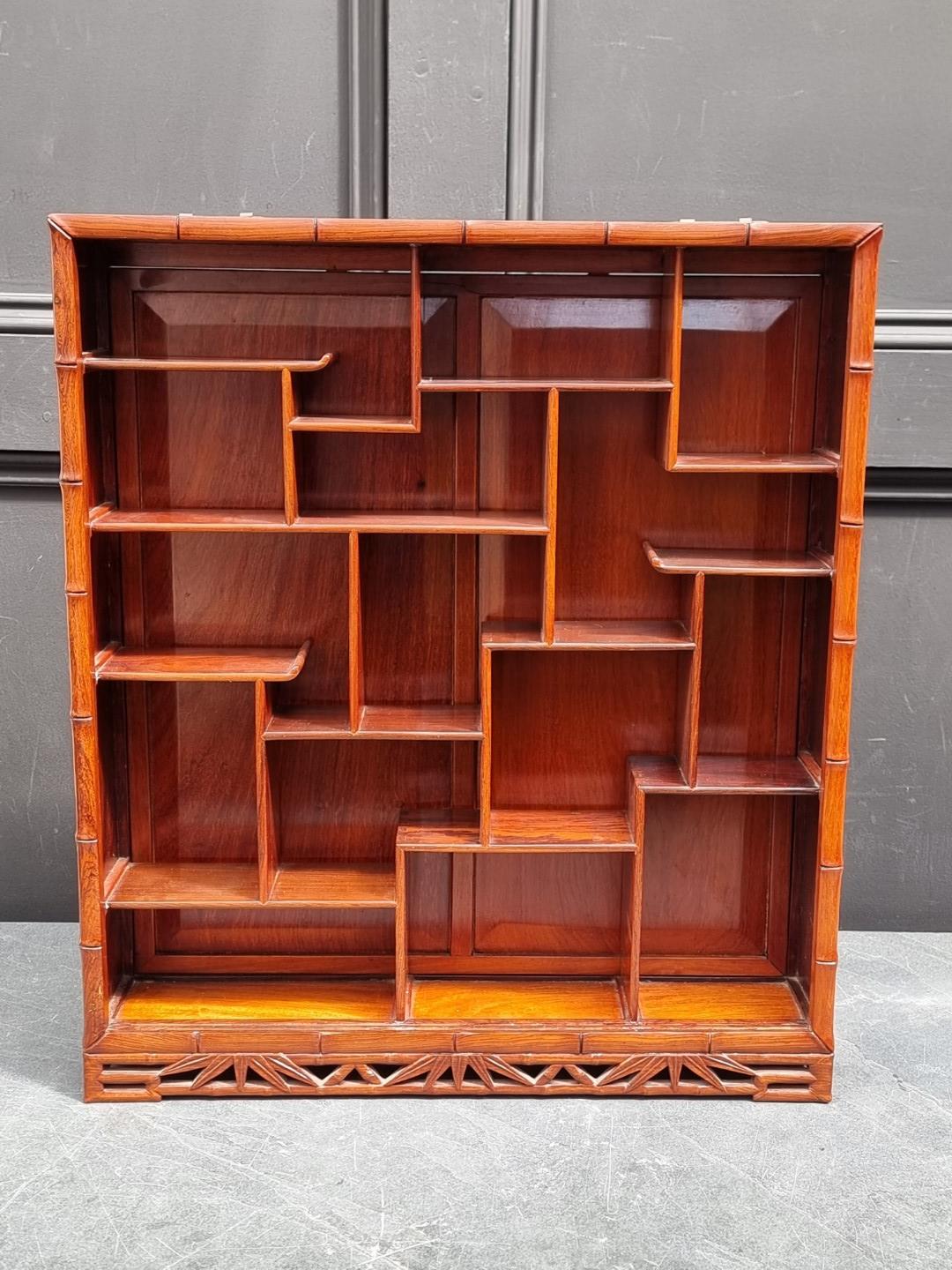 A Chinese carved hardwood hanging display cabinet, 57.5 x 50cm.