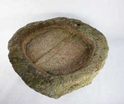 A large shallow circular granite trough