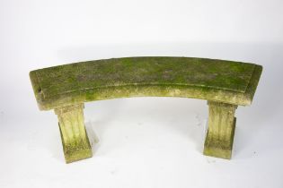 A curved limestone garden bench