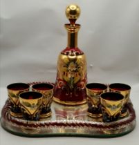 A Bohemian ruby and gilt glass decanter and six glasses, on tray