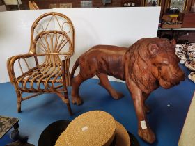 A child's canework armchair, and a large carved wooden lion model