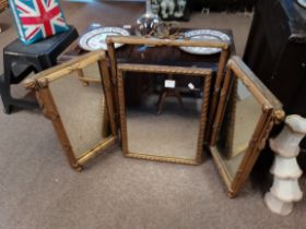 An early gilt dressing table triple mirror with rams head decoration and regency style bows