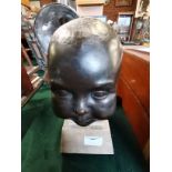 A full life size bronze bust of a baby on granite plinth