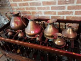 A set of 8 copper measuring jugs