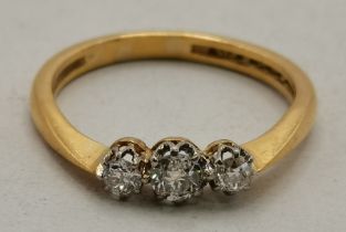 A yellow metal three-stone ring
