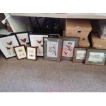 A group of assorted prints and embroideries, framed