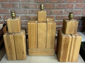 A trio of cuboid oak table lamps