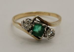 A 9 carat gold and platinum emerald and diamond three-stone crossover ring