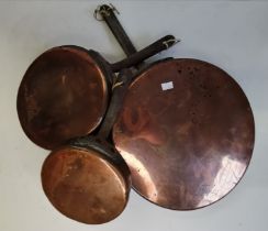 A graduated set of three copper skillets, early 20th Century