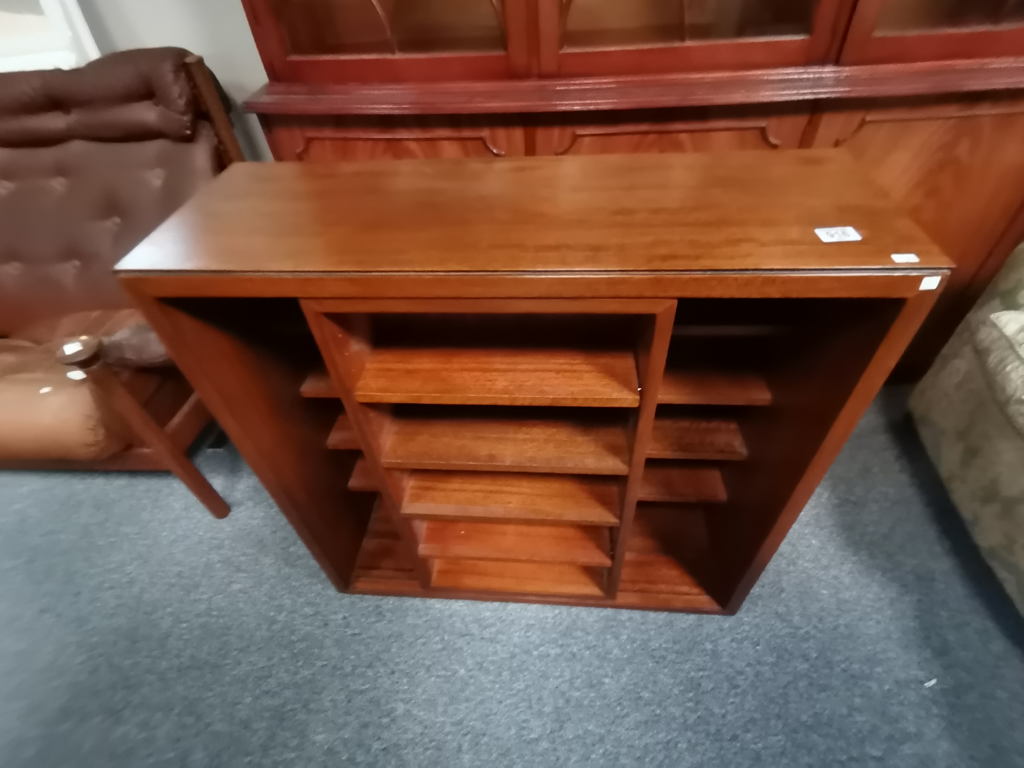 A teak set of bookshelves with sliding front shelf