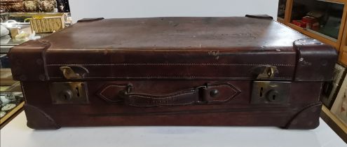 An early 20th Century tan leather suitcase with fitted interior