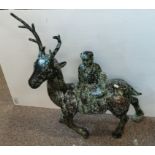 A Chinese bronzed metal sculpture of a figure riding a deer