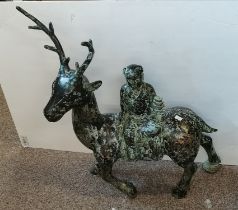 A Chinese bronzed metal sculpture of a figure riding a deer