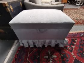 A pale blue upholstered ottoman