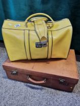 A tan leather suitcase and a yellow leather holdall