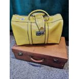 A tan leather suitcase and a yellow leather holdall