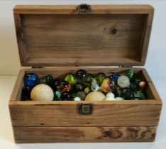 Collection of large and small marbles in wooden box