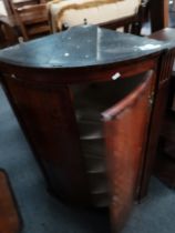 A bow fronted Georgian oak corner cupboard and Bergere rocking chair