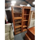 A wooden bookcase and a triple-door tall cabinet