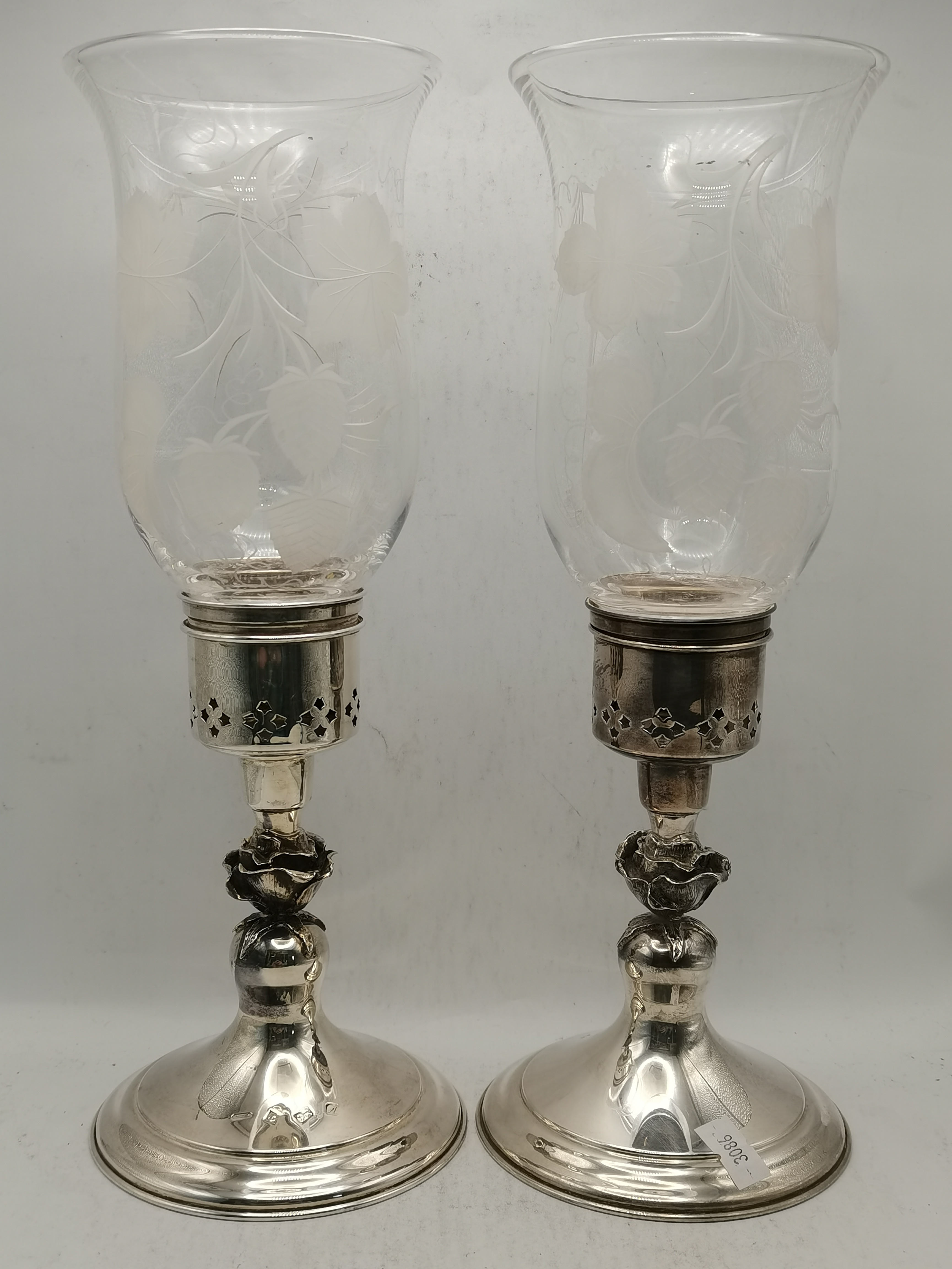 A pair of Elizabeth II silver hurricane lamp candlesticks
