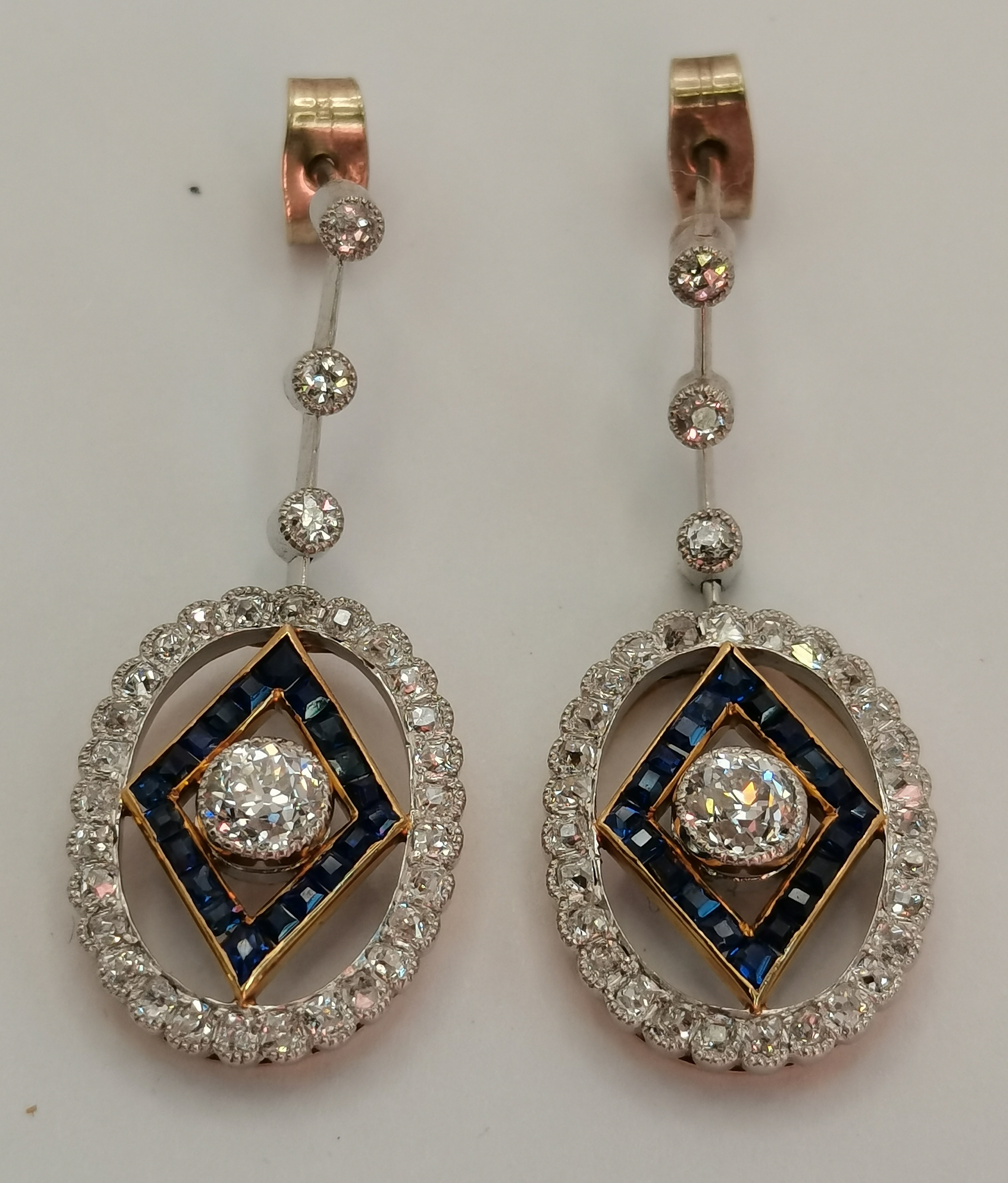 A pair of Art Deco platinum and 18 carat gold diamond and sapphire pendant earrings