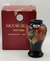 A Moorcroft 10cm high vase with original box in the pomegranate pattern