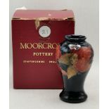 A Moorcroft 10cm high vase with original box in the pomegranate pattern