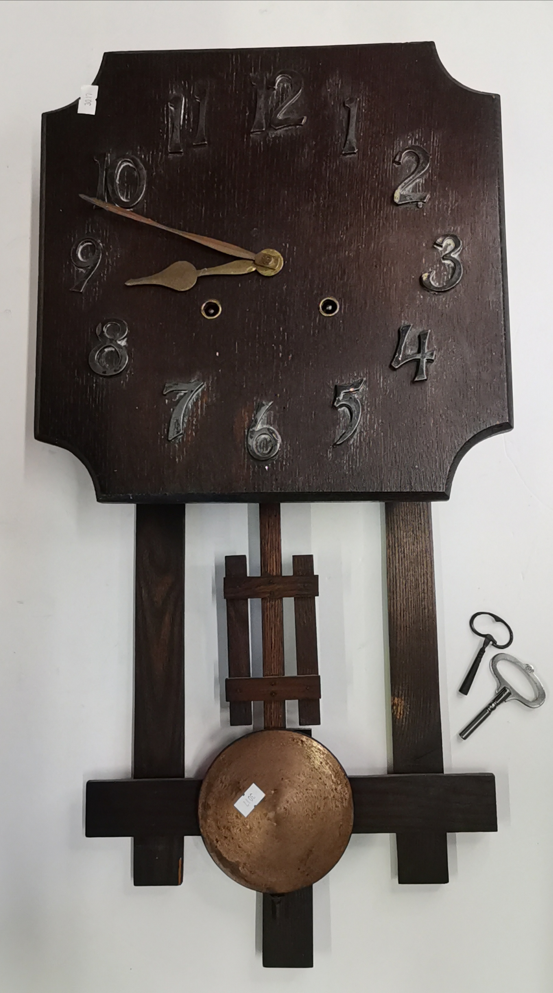 An Arts and Crafts style oak wall clock made by W.M Gilbert clock co.