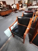 A pair of mid-century Scandinavian style teak and leather armchairs, with black leather seats and ba