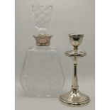 A silver candlestick and silver-mounted glass bottle