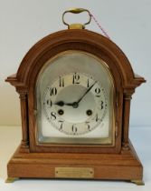 An Antique oak mantel clock with brass bracket feet