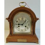 An Antique oak mantel clock with brass bracket feet