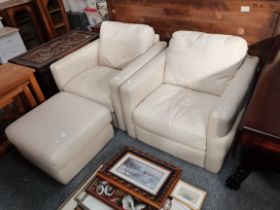 A pair of cream leather arm chairs and matching st