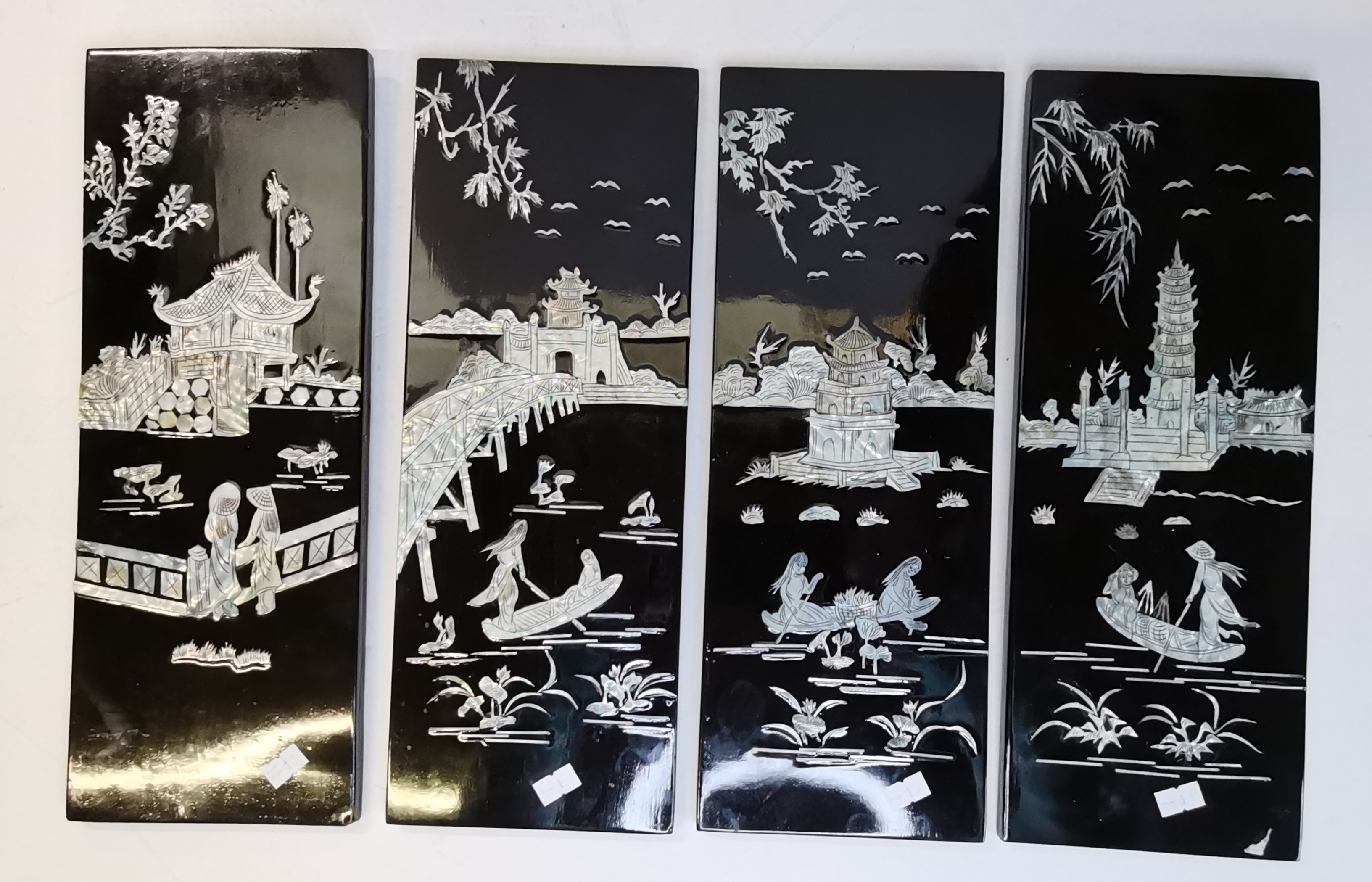 Four oriental black lacquered and mother-of-pearl decorated wooden panels