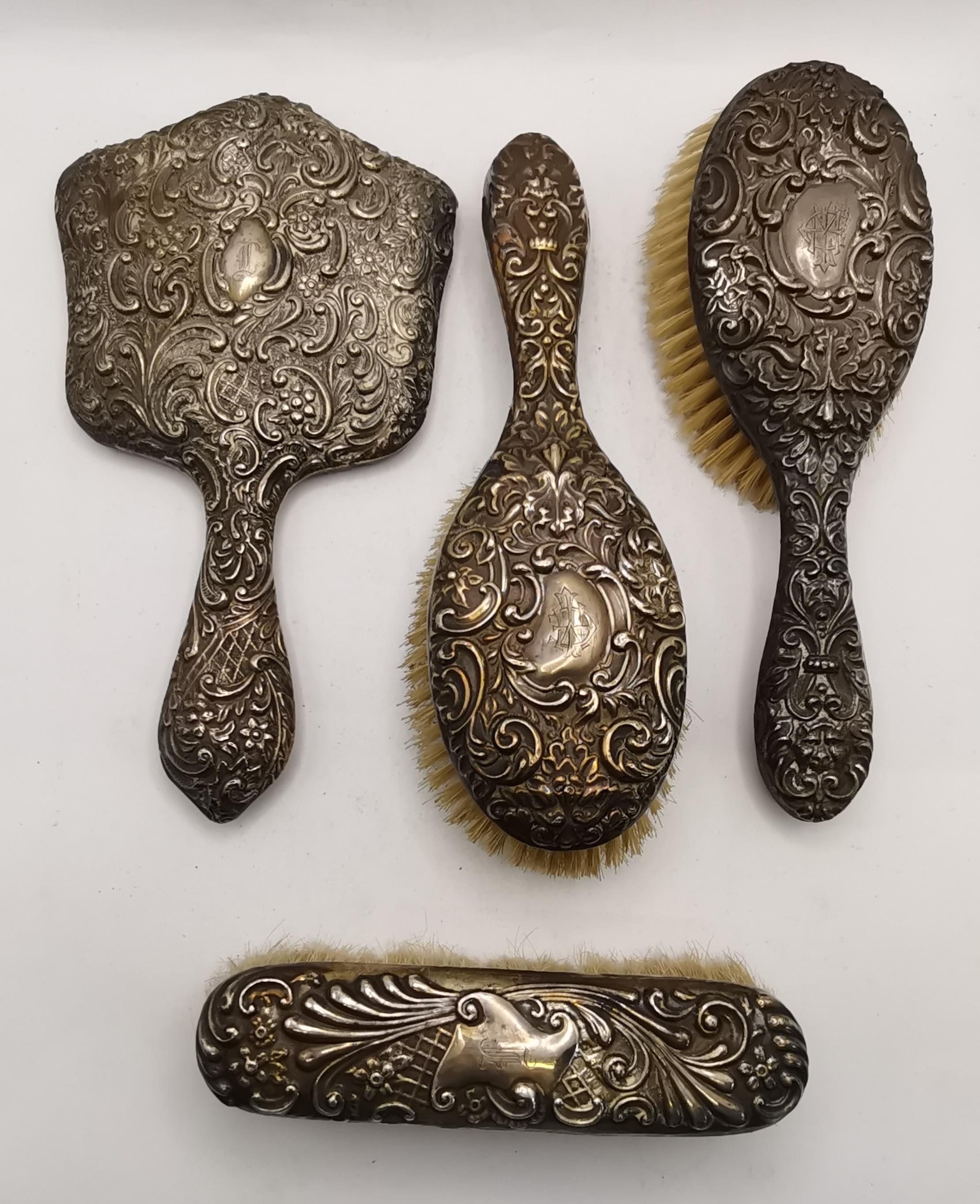 A late Victorian harlequin silver four-piece dressing table brush and mirror set