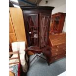 An astragal glazed mahogany corner cabinet on serpentine stand