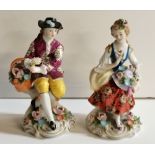 A pair of 14cm figurines of a boy and girl with flowers