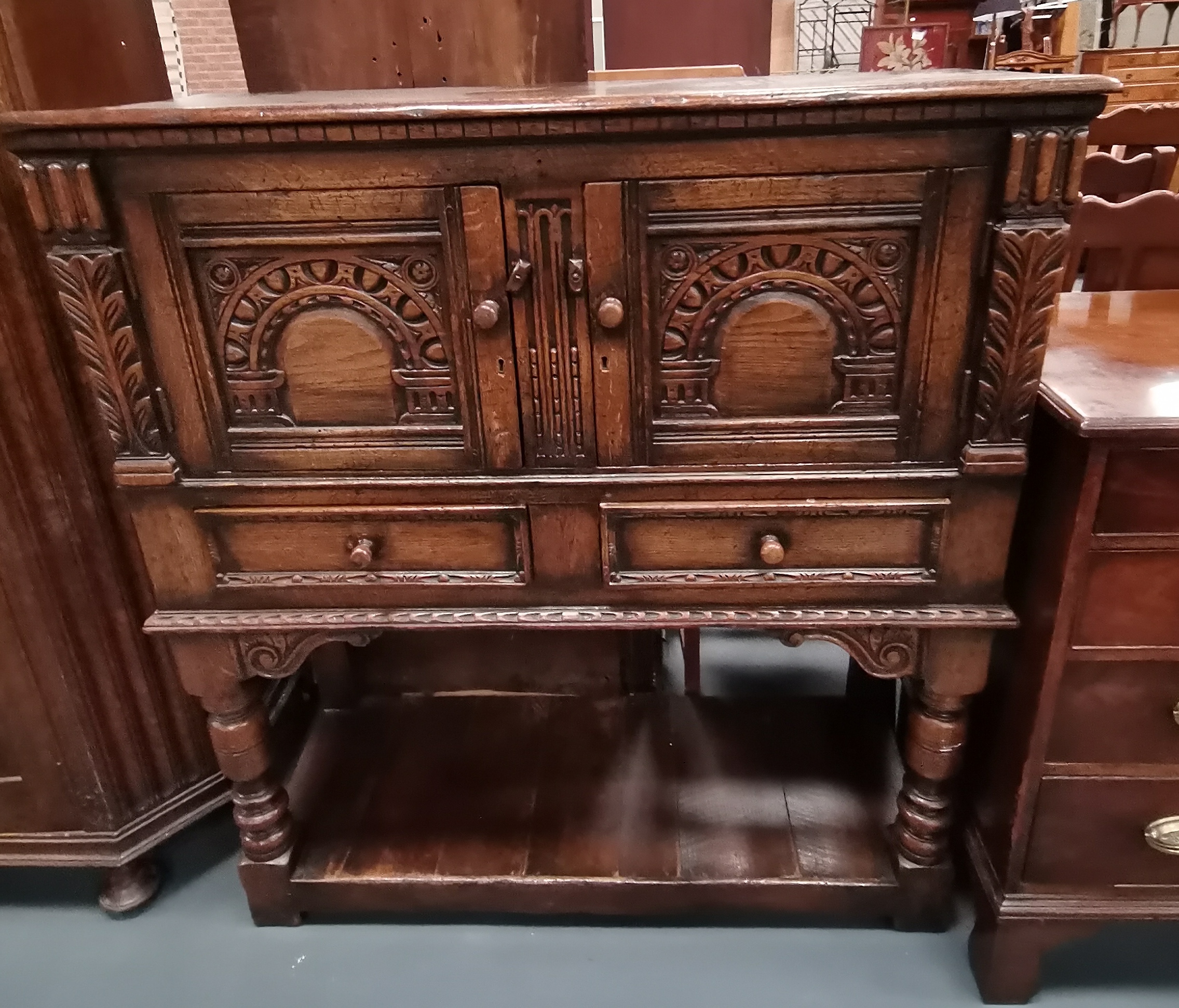 A Titchmarsh,arsh and Goodwin style carved oak sewing cabinet