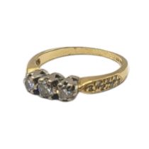 AN EARLY 20TH CENTURY 18CT GOLD AND DIAMOND THREE STONE RING Having a row of round cut diamonds in a