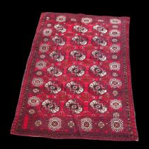 A VINTAGE WOOLEN TRIBAL BOKHARA RUG On red ground. (115cm x 165cm) Condition: good overall