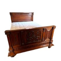 A 19TH CENTURY FRENCH CARVED MAHOGANY DOUBLE BEDSTEAD The heavily decorated foot board with urns