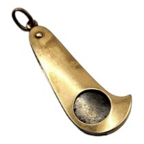 AN EARLY 20TH CENTURY YELLOW METAL CIGAR CUTTER Curved form with steel blade. (approx 5cm)